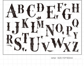 May include: Black and white alphabet letters in a decorative font style. The letters are stylized with flourishes and details. The letters are approximately 110 x 160 mm in size.