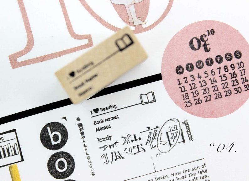 Puede incluir: Un collage de elementos de papeler&iacute;a con un sello de madera, un calendario rosa de octubre y texto japon&eacute;s. El sello tiene un icono de libro y texto. El tema es la lectura y el diario.