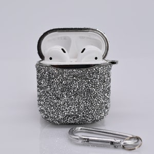 May include: A silver sparkly case for wireless earbuds with a silver carabiner clip.
