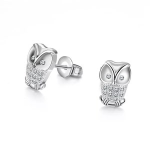 May include: A pair of silver owl stud earrings with clear crystal accents.