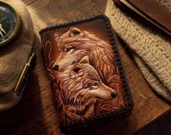 May include: A rectangular brown leather wallet featuring a detailed embossed design of two wolves. The wallet has a dark braided leather edge finish and a smooth, tan-colored surface with intricate fur textures and shading throughout the artwork.