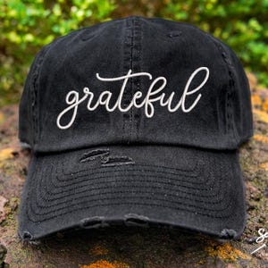 Peut inclure: Casquette de baseball noire usée avec un texte brodé blanc qui dit "grateful".