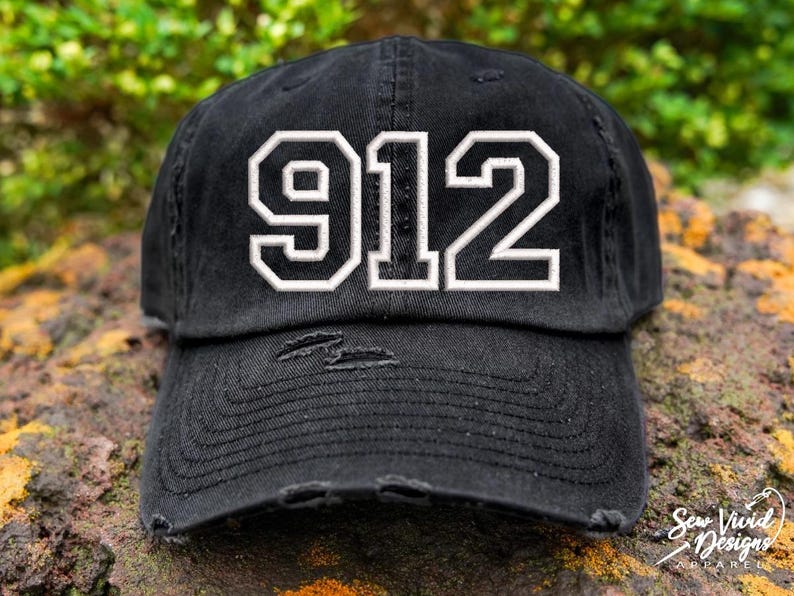 K&ouml;nnte beinhalten: Schwarze, abgenutzte Baseballkappe mit wei&szlig; gesticktem Text "912" auf der Vorderseite.