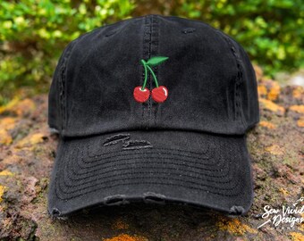 May include: A black distressed baseball cap with a red cherry embroidered on the front.