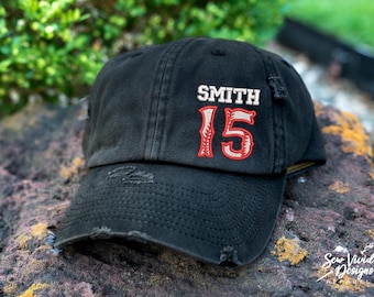 May include: A black distressed baseball cap with a white embroidered name "SMITH" and red embroidered number "15".