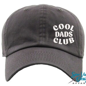 May include: A gray baseball cap with white embroidered text that reads "Cool Dads Club".