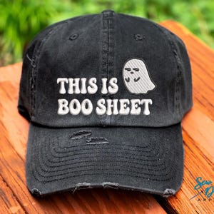 May include: Black baseball cap with a white embroidered ghost and the text "This is Boo Sheet".