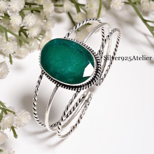 Può includere: Un bracciale a fascia in argento sterling con una grande pietra preziosa verde ovale sfaccettata incastonata in una lunetta dentellata. Il cinturino è composto da tre fili distinti, due dei quali hanno una trama a corda ritorta. Testo Silver925Atelier.