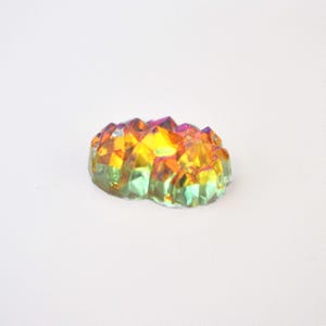 May include: A small, iridescent crystal cluster with a rainbow of colors, including yellow, green, and purple.