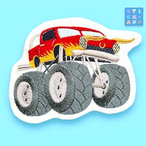 Könnte beinhalten: Roter Monstertruck mit gelben Flammen und großen grauen Reifen. Der Truck hat einen weißen Hintergrund.