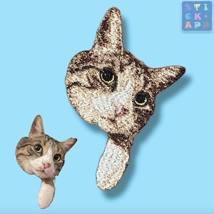 Könnte beinhalten: Zwei gestickte Aufnäher mit einem braunen Tabby-Kater mit weißen Markierungen. Der Kater auf dem oberen Aufnäher schaut nach rechts, während der Kater auf dem unteren Aufnäher nach links schaut. Beide Aufnäher haben einen weißen Hintergrund.