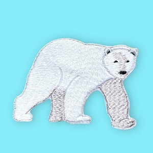 Könnte beinhalten: Ein weiß gestickter Eisbär-Patch auf hellblauem Hintergrund.