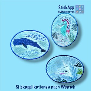 Könnte beinhalten: Drei ovale Stickapplikationen mit Meeresmotiven. Ein Aufnäher zeigt einen dunkelblauen Wal, ein weiterer ein türkisfarbenes Seepferdchen mit Korallen und der dritte einen weißen Hai. Der Text StickApp CMBünning GbR und Stickapplikationen nach Wunsch ist zu sehen.