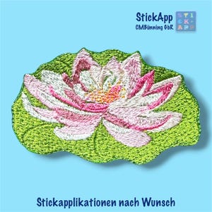 Könnte beinhalten: Ein gestickter Aufnäher mit einer rosa-weißen Lotusblüte auf einem grünen Seerosenblatt. Das Design zeigt detaillierte Stickereien mit gelben Akzenten in der Mitte. Der Text StickApp CMBünning GbR und Stickapplikationen nach Wunsch ist zu sehen.