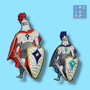 Könnte beinhalten: Zwei gestickte Bügelbilder von Rittern in Rüstung, einer mit einem roten Umhang und der andere mit einem blauen Umhang. Beide Ritter halten Schwerter und Schilde mit einem rautenförmigen Design.
