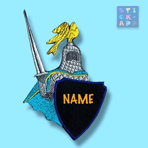 Könnte beinhalten: Ein gestickter Aufnäher mit einem silbernen Ritterhelm mit gelbem Federbusch, einem silbernen Schwert und einem blauen Umhang. Ein schwarzer Schild mit blauem Rand befindet sich im Vordergrund und zeigt den orangefarbenen Text NAME.