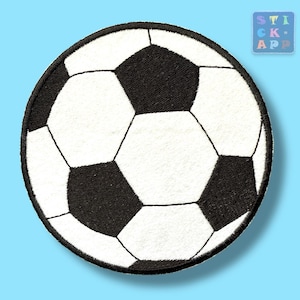 Könnte beinhalten: Ein kreisförmiger, bestickter Aufnäher mit einem klassischen Fußball-Design aus abwechselnden schwarzen Fünfecken und weißen Sechsecken. Der Aufnäher hat einen dicken, schwarz umstickten Rand und eine strukturierte Stoffoberfläche mit dem Muster.