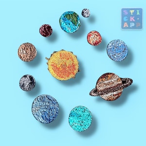 Könnte beinhalten: Eine Sammlung von Aufklebern zum Thema Planeten, darunter Sonne, Erde und Saturn, angeordnet auf hellblauem Hintergrund. Die Aufkleber haben ein strukturiertes, gesticktes Aussehen mit leuchtenden Farben. Das Bild enthält auch einen Aufkleber mit dem Text "STICK APP".