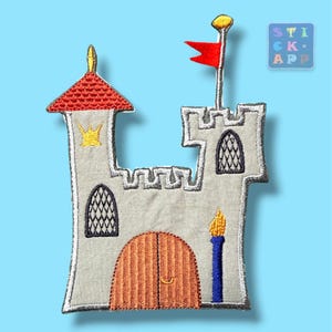 Könnte beinhalten: Ein gestickter Aufnäher in Form einer Burg mit hellgrauen Mauern, einem roten Dach und einer braunen Bogentür. Er zeigt eine rote Flagge an einem Mast, ein gelbes Kronendetail, zwei Bogenfenster mit schwarzem Gittermuster und eine blaue Fackel.