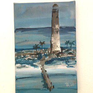 Könnte beinhalten: Ein Gemälde, das einen Leuchtturm auf einer kleinen Insel mit Palmen zeigt. Der Leuchtturm ist braun und weiß und das Wasser ist blau. Das Gemälde ist unten rechts mit "R20" signiert.