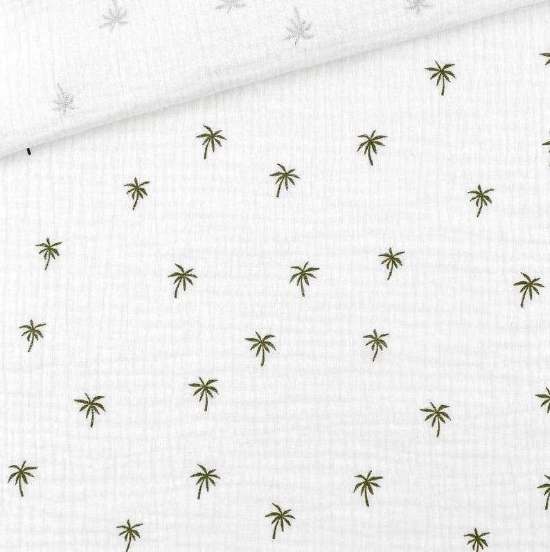 May include: White fabric with a repeating pattern of small, dark green palm trees. The fabric has a slightly textured appearance, with a subtle crinkled effect. The palm tree design is evenly spaced across the surface.