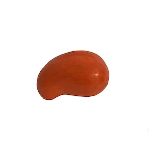 Op de afbeelding: Een klein, oranje houten object met een gladde, afgeronde vorm. Het object heeft een enigszins onregelmatige vorm, met een kleine uitsteeksel aan één kant. De houtnerf is zichtbaar en voegt textuur toe aan het oppervlak. Op een witte achtergrond.
