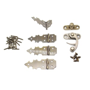Può includere: Set di tre cerniere in ottone ornate con dettagli decorativi, un chiavistello in ottone con una maniglia a leva e un mucchio di viti. Le cerniere sono progettate per essere utilizzate su porte o armadi in legno.