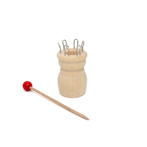 May include: A wooden knitting loom with metal hooks and a red wooden knitting needle.