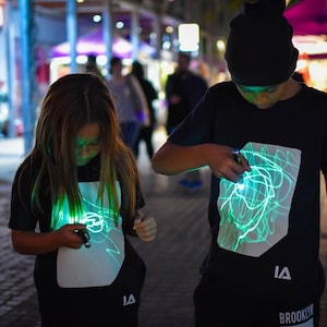 Illuminated Apparel Kinder-Interaktives grünes Glühen-T-Shirt im schwarzen / grünen Glühen