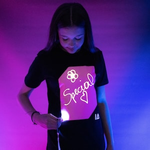 T-shirt interactif rose phosphorescent pour enfants en noir / lueur rose image 1