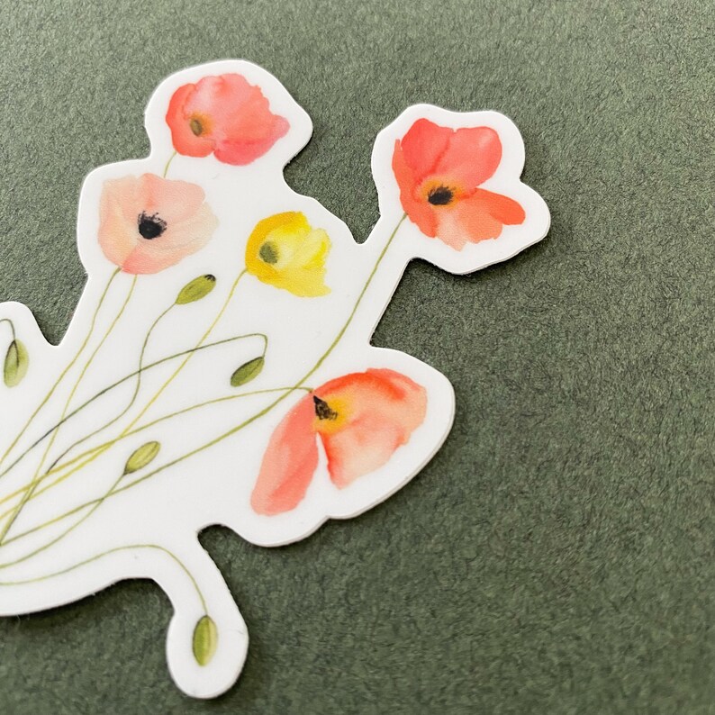 May include: A white sticker with a watercolor illustration of a bouquet of red, orange, and yellow flowers. The flowers are stylized and have a delicate, whimsical look.