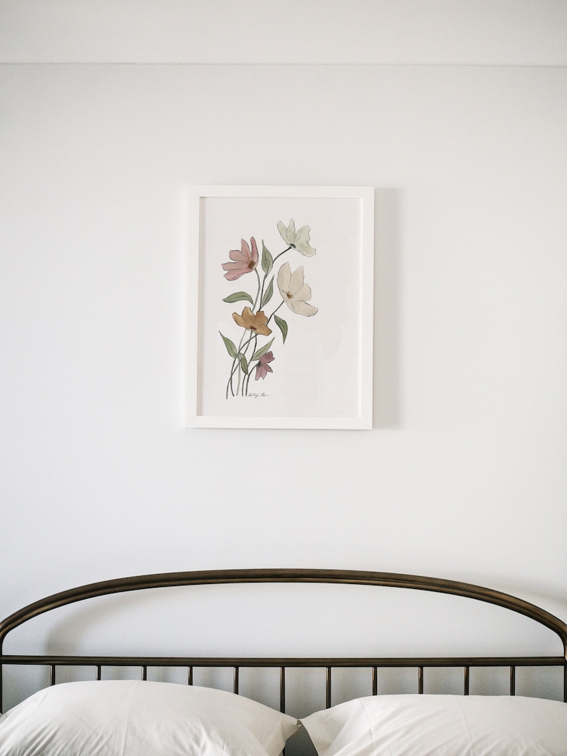 May include: A white framed print of a watercolor painting of a bouquet of pink, yellow, and white flowers on a white background.