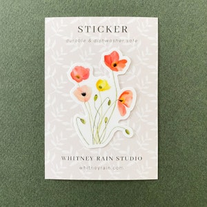 May include: A sticker featuring a watercolor illustration of a bouquet of red, orange, and yellow poppies. The sticker is labeled "STICKER durable & dishwasher safe" and "WHITNEY RAIN STUDIO whitneyrain.com".