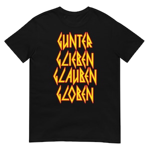 May include: Black t-shirt with the words "GUNTER GLIEBEN GLAUBEN GLOBEN" in yellow and red letters, styled in a heavy metal font.