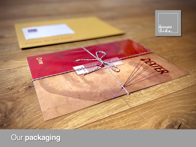 May include: A red and brown print with the word "Dexter" on it is wrapped in a clear plastic sleeve and tied with twine. The print is being packaged in a brown envelope.