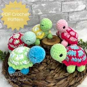 Può includere: Un set di cinque giocattoli amigurumi a forma di tartaruga all'uncinetto in vari colori, tra cui verde, rosa, blu e giallo. Le tartarughe hanno gusci di diversi colori con una varietà di motivi. L'immagine include il testo "NO SEW PDF Crochet Pattern".