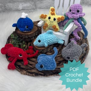 May include: A collection of handmade crochet sea creatures, including a blue whale, yellow starfish, purple jellyfish, blue dolphin, red crab, blue stingray, and gray shark. The text "PDF Crochet Bundle" is also visible.