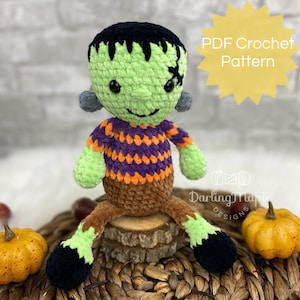 May include: A handmade crochet Frankenstein's monster doll with a green face, black hair, and a stitched scar. The doll wears a purple and orange striped shirt and brown pants. The text "PDF Crochet Pattern" is visible.