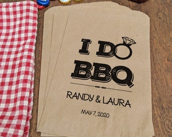 May include: Brown paper favor bags with the text "I Do BBQ" in black with a diamond ring graphic. The text "Randy & Laura" and "May 7, 2020" are printed below the graphic.