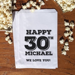 Może przedstawiać: Biała papierowa torba z czarnym tekstem, kt&oacute;ry brzmi "Happy 30th Michael We Love You!"