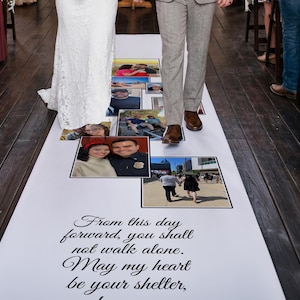 May include: A white wedding aisle runner featuring a collage of various personal photographs and the printed text: From this day forward, you shall not walk alone. May my heart be your shelter. The runner is positioned on a dark wooden floor.