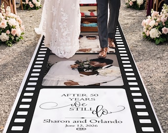 May include: A long wedding aisle runner designed like a film strip with black borders and white frames. The runner features printed photographs of a couple and the text: AFTER 50 YEARS WE STILL DO, Sharon and Orlando, June 12, 2026, on a white background.
