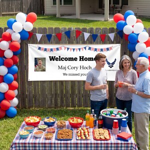 Peut inclure: Sc&egrave;ne de f&ecirc;te dans un jardin avec une banni&egrave;re "Welcome Home Maj Cory Hoch". Des ballons et des d&eacute;corations rouges, blancs et bleus sont pr&eacute;sents. Une table est dress&eacute;e avec des collations et des boissons, et des gens sont rassembl&eacute;s.
