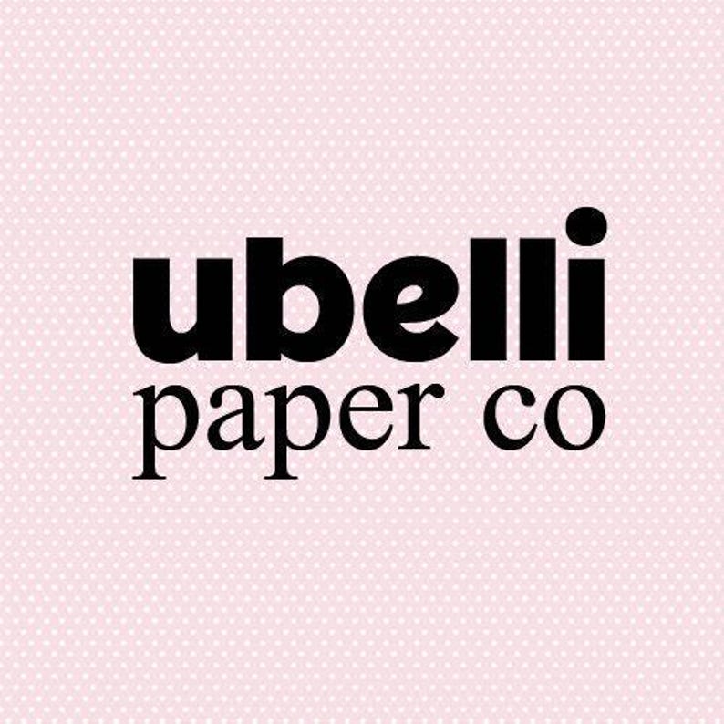 Op de afbeelding: Het logo van Ubelli Paper Co. in vette, zwarte letters tegen een lichtroze achtergrond met een subtiel wit stippenpatroon. De woorden 'ubelli' en 'paper co' zijn gestapeld.