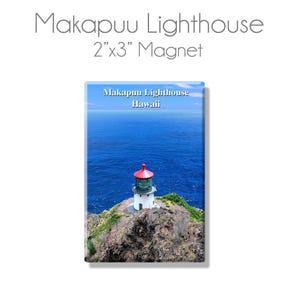 May include: A 2" x 3" magnet featuring a white lighthouse with a red roof on a cliff overlooking a blue ocean. The text "Makapuu Lighthouse Hawaii" is printed on the magnet.