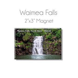 May include: A rectangular magnet featuring a scenic image of Waimea Falls in Hawaii. The magnet measures 2" x 3" and displays a waterfall cascading into a pool, surrounded by lush greenery. The text "Waimea Falls, North Shore Hawaii" is visible.