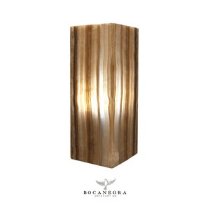 May include: A rectangular, light brown onyx lamp with a white and brown striped pattern. The lamp is lit and the light shines through the onyx.
