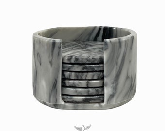 May include: Set of six gray marble coasters with a matching gray marble holder. The coasters are stacked inside the holder.