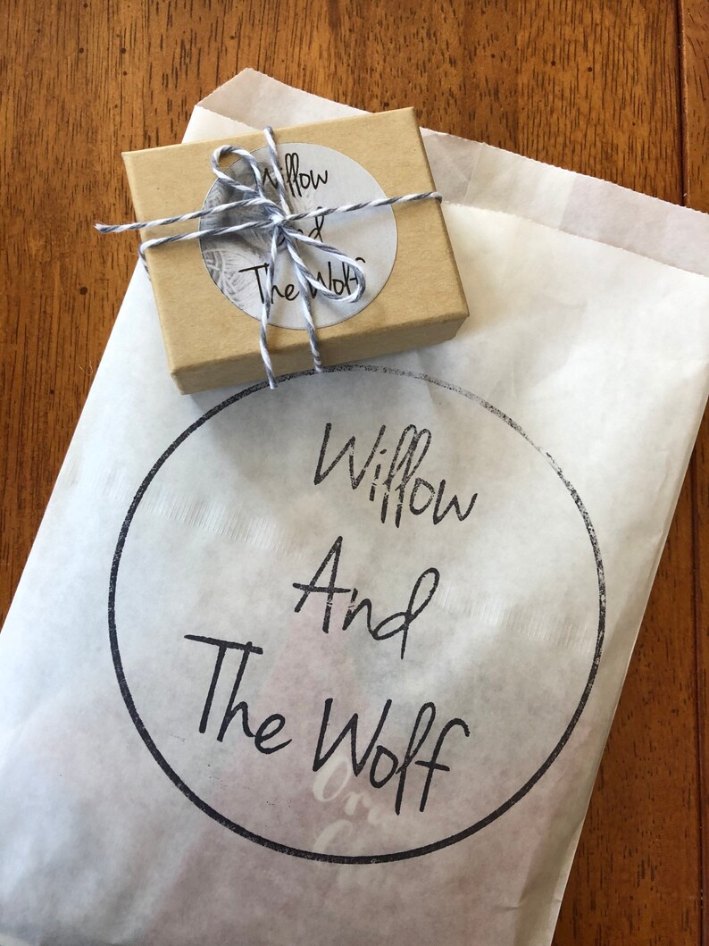 Puede incluir: Una bolsa de papel marr&oacute;n con un logotipo circular blanco que dice "Willow And The Wolf". La bolsa est&aacute; atada con una cuerda blanca y tiene una peque&ntilde;a caja marr&oacute;n dentro.