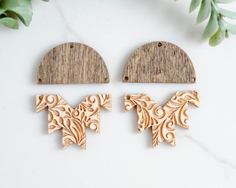 May include: A pair of unfinished wooden earrings with a floral pattern. The earrings are made of two pieces, a top piece that is a half-circle and a bottom piece that is a geometric shape.